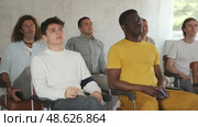 Portrait of interested adult man attentively listening to lecture, sitting in auditorium full of male students. Стоковое видео, видеограф Яков Филимонов / Фотобанк Лори