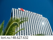 Tall hotel building Marriott under a clear blue sky surrounded by palm trees in a vibrant urban setting.Batumi, Georgia - October 10, 2024. Редакционное фото, фотограф Климов Денис / Фотобанк Лори