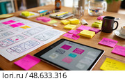 Creative workspace filled with design prototypes and colorful sticky notes in a bright and modern office environment. Стоковое AI-изображение, AI-художник Сергей Толмачёв / Фотобанк Лори