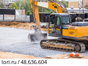 An excavator on a construction site in close-up. The excavator rams the crushed stone with a bucket for construction. Heavy machinery for construction and landscaping. Стоковое фото, фотограф Photojuli / Фотобанк Лори