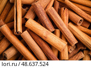 Cinnamon background. Pile of cinnamons stick top view. Cinnamomum cassia close up. Spice for the Holidays. Assortment of spices. Cinnamon bark is a spice used for sweet and savory dish. Стоковое AI-изображение, AI-художник Марина Демидюк / Фотобанк Лори