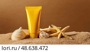 Yellow Sunscreen cream tube, starfishes and seashells on a sand top view. Cosmetic mockup. Sunblock lotion on sandy beach background. Summer vacation care concept, sun screen product, spf uv protect. Стоковое AI-изображение, AI-художник Марина Демидюк / Фотобанк Лори
