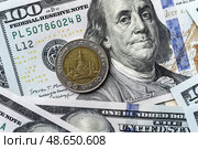 Close-up of a Thai Baht coin on US 100 dollar bills in focus. Стоковое фото, фотограф Емельянов Евгений Викторович / Фотобанк Лори