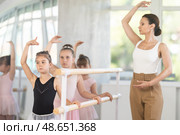 Little ballerinas learn to get into fourth position in ballet class. Choreographer helps them with this. Стоковое фото, фотограф Яков Филимонов / Фотобанк Лори