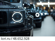 Black off-road vehicles lined up in a modern showroom during the day. Стоковое AI-изображение, AI-художник Михаил Коханчиков / Фотобанк Лори