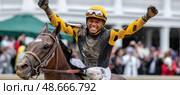 Victorious jockey celebrating winning horse race at churchill downs. Стоковое AI-изображение, AI-художник Юрий Поздников / Фотобанк Лори