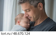 Father holding sleeping newborn baby near window. Стоковое AI-видео, аниматор Юрий Поздников / Фотобанк Лори