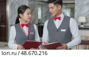 Hotel staff discussing work tasks with clipboards. Стоковое AI-видео, аниматор Юрий Поздников / Фотобанк Лори