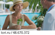 Elegant woman sipping cocktail by the poolside. Стоковое AI-видео, аниматор Юрий Поздников / Фотобанк Лори