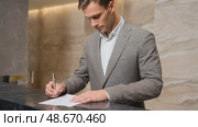 Businessman signing document at hotel reception. Стоковое AI-видео, аниматор Юрий Поздников / Фотобанк Лори