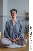 Peaceful woman meditating in lotus pose at home. Стоковое AI-видео, аниматор Юрий Поздников / Фотобанк Лори
