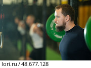 Determined young guy working out with weight rod during crossfit workout. Стоковое фото, фотограф Яков Филимонов / Фотобанк Лори