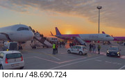 Aircraft boarding at sunset with passengers preparing for flight. Редакционное видео, видеограф Антон Гвоздиков / Фотобанк Лори