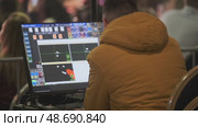 Technician operating computer to manage stage lighting system during event setup. Стоковое видео, видеограф Антон Гвоздиков / Фотобанк Лори