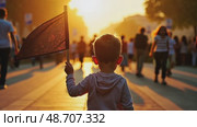 A child holding a small black flag, standing in a crowded street at sunset, the golden light casting long shadows as people march silently. Стоковое AI-видео, аниматор Sergey Grishin / Фотобанк Лори
