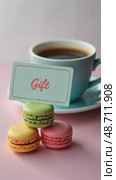 A creative shot of a gift card placed on a stack of colorful macarons, with a cup of coffee in the background. Стоковое AI-видео, аниматор Sergey Grishin / Фотобанк Лори
