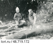 МУжчина с мальчиком у костра и шалаша в лесу. Стоковое фото, фотограф Retro / Фотобанк Лори