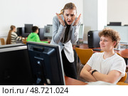 Frustrated teacher talking to neglectful teenage student in computer class. Стоковое фото, фотограф Яков Филимонов / Фотобанк Лори