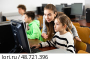 Female teacher consulting teenage girl studying in information technology class. Стоковое фото, фотограф Яков Филимонов / Фотобанк Лори
