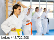 Teenage girl in kimono practicing punches and blocks during martial arts training. Стоковое фото, фотограф Яков Филимонов / Фотобанк Лори