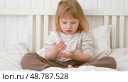Baby girl finger applying moisturizing cream on her hand in white bedroom. Child puts lotion on hands. Skin care. Clean smooth body skin. Skincare, wellness, hygiene. Soft natural light, low contrast. Стоковое видео, видеограф Марина Демидюк / Фотобанк Лори