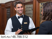 Hotel concierge assisting a guest in lobby. Стоковое AI-изображение, AI-художник Юрий Поздников / Фотобанк Лори
