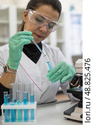 A female microbiologist in the laboratory works with samples in a test tube. Working with a microscope and test tubes. Стоковое фото, фотограф Регина Ерофеева / Фотобанк Лори