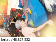 Mature female fitness climber training at bouldering gym.Woman rise up on artificial climbing wall. Стоковое фото, фотограф Яков Филимонов / Фотобанк Лори