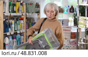 Elderly woman buys convenient lightweight ironing board at a hardware store. Стоковое видео, видеограф Яков Филимонов / Фотобанк Лори