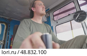 A male crane operator demonstrates his expertise as he navigates the crane's joystick with precision and focus. He is seated in the cabin, clearly engaged in his task as he operates heavy machinery. Стоковое видео, видеограф Владимир Разгуляев / Фотобанк Лори