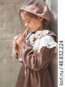 Vintage women's accessories and retro-style clothing. A small, beautiful girl with bows in her hair, in a beige dress and a beret outdoors. Стоковое фото, фотограф Photojuli / Фотобанк Лори