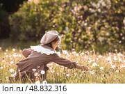 Vintage women's accessories and retro-style clothing. A small, beautiful girl with bows in her hair, in a beige dress and a beret outdoors. Стоковое фото, фотограф Photojuli / Фотобанк Лори