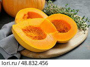 Cutting Fresh Pumpkins on Board. Baked pumpkin. Sliced raw Cucurbita maxima and spices for preparing soup, warm salad, fall dish. Thanksgiving food. Roasted vegetable in olive oil salt pepper, herbs. Стоковое AI-изображение, AI-художник Марина Демидюк / Фотобанк Лори
