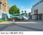 Автогидроподъёмник Isuzu Elf возле строительного объекта. Редакционное фото, фотограф Лариса Веселова / Фотобанк Лори