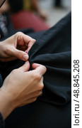 Hands Steady the Black Cloth as a Woman Prepares a Banner for the Ashura Process, Her Fingers Trembling With Concentration. Стоковое AI-изображение, AI-художник Sergey Grishin / Фотобанк Лори