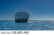 A lonely little rocky island in the blue ocean. Traces of bird droppings on steep slopes. The waves are foaming all around. Clear azure sky. Madagascar. Copy space. Стоковое фото, фотограф Вера Ивановна Кубарева / Фотобанк Лори
