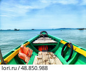Green fishing boat navigates the calm blue waters near Phu Quoc Island on a sunny day, showing other boats and the distant coastline. Стоковое фото, фотограф Кривошеина Елена Леонидовна / Фотобанк Лори