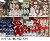 Витрина с конфетами в кондитерской. Трюфели ручной работы "Писатели России", "Поэты России", трюфель "Президент", "Мое сердце", "Ильич", "Гагарин", "Клубника в шоколаде" (Кондитерская фабрика "Джи Си – Золотые конфеты" (Golden Candies). Город Петероф, Торговая площадь. Россия. Редакционное фото, фотограф Щеголева Ольга / Фотобанк Лори