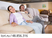 Cheerful couple trying out sofa in furniture showroom. Стоковое фото, фотограф Яков Филимонов / Фотобанк Лори