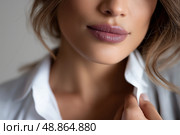 Woman with soft lips adjusting her collar in a calm indoor setting. Женщина с мягкими губами поправляет воротник в спокойном помещении. Стоковое AI-изображение, AI-художник Katsiaryna Repich / Фотобанк Лори