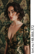 A woman with short, curly, dark hair poses against a vintage floral backdrop, wearing a green and gold floral dress with a plunging neckline. Стоковое AI-изображение, AI-художник Данила Большаков / Фотобанк Лори