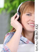 Woman listening to music with her headphones. Стоковое фото, агентство Ingram Publishing / Фотобанк Лори