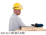 Suspicious man looking at an electric screwdriver. Стоковое фото, агентство Ingram Publishing / Фотобанк Лори