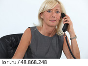 Businesswoman answering the telephone. Стоковое фото, агентство Ingram Publishing / Фотобанк Лори