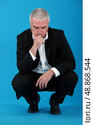 thoughtful mature man hunkering down. Стоковое фото, агентство Ingram Publishing / Фотобанк Лори