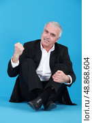 An angry man sitting cross-legged. Стоковое фото, агентство Ingram Publishing / Фотобанк Лори