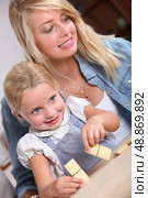 Young woman and little girl playing with dominoes. Стоковое фото, агентство Ingram Publishing / Фотобанк Лори