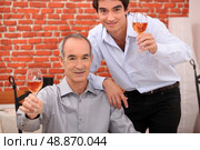 Men raising their glasses in a toast. Стоковое фото, агентство Ingram Publishing / Фотобанк Лори
