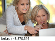 Daughter showing mother how to use  the Internet. Стоковое фото, агентство Ingram Publishing / Фотобанк Лори