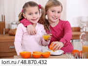 two little girls drinking orange juice. Стоковое фото, агентство Ingram Publishing / Фотобанк Лори